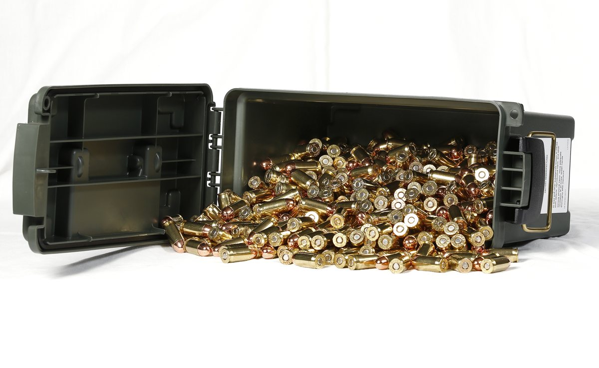 An open green ammo can spilling loose .45 ACP rounds on a white background.